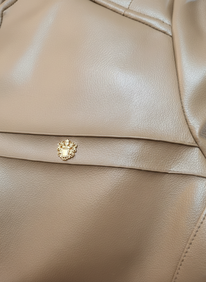 Gold emblem detail on beige leather